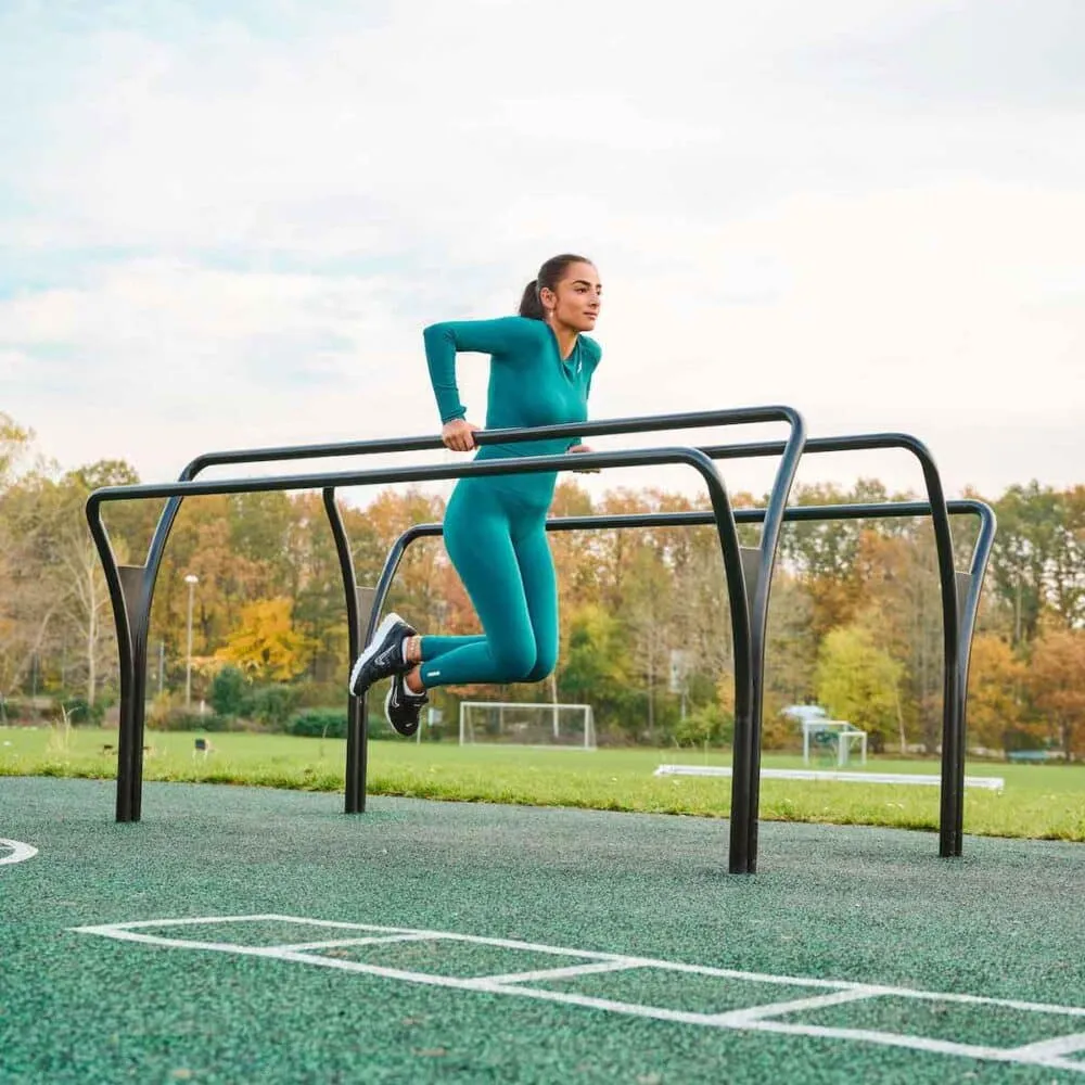 Athlete aligning stride beside wooden pasture fence rails